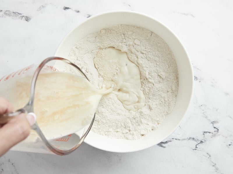 Overhead shot of wet ingredients being mixed into dry ingredients.