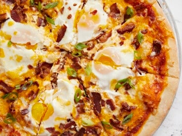 Close up of a sliced breakfast pizza.