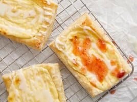 Overhead shot of three cheese danish on a cooling rack.