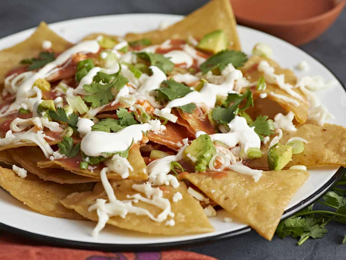 Side shot of chilaquiles served on a white plate.