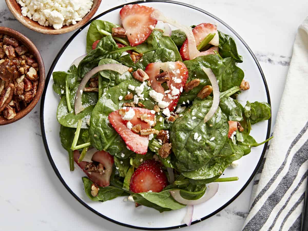 Overhead close up shot of plated strawberry spinach salad.