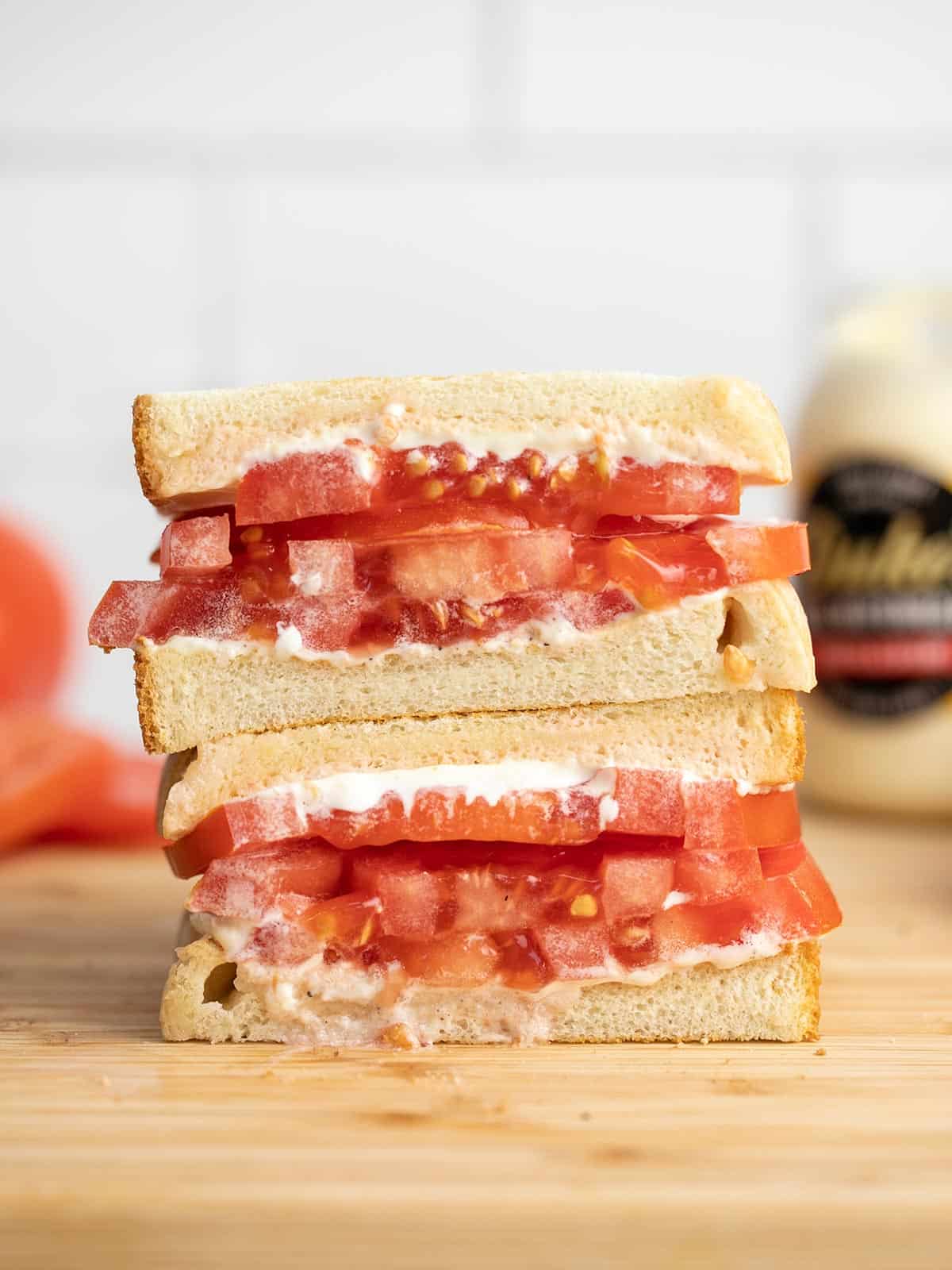 Side view of a sliced and stacked tomato sandwich.