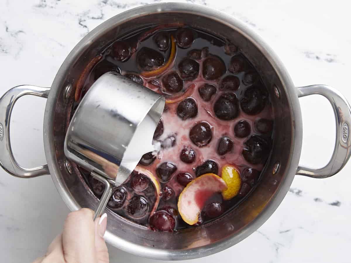 Cornstarch slurry being added to the sauce.