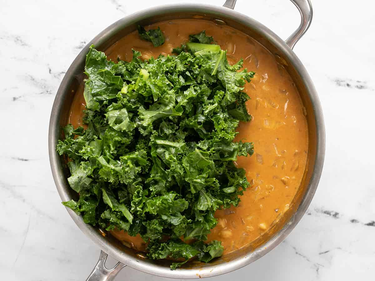 Fresh kale added to the skillet.