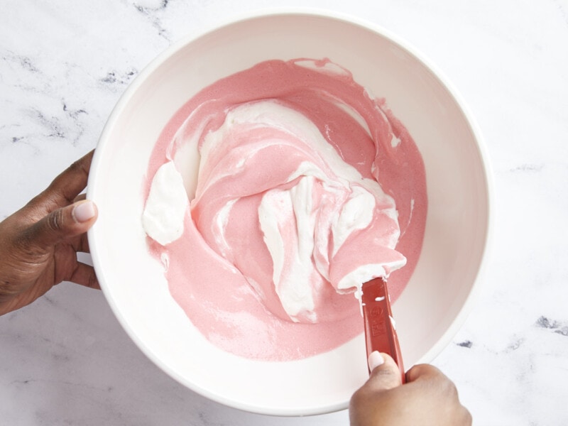 Strawberry gelatin mixture and whipped cream folded together.