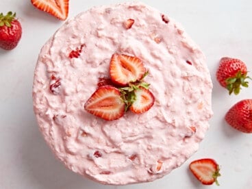 Overhead photo of a whole full of jello salad topped with sliced strawberries.