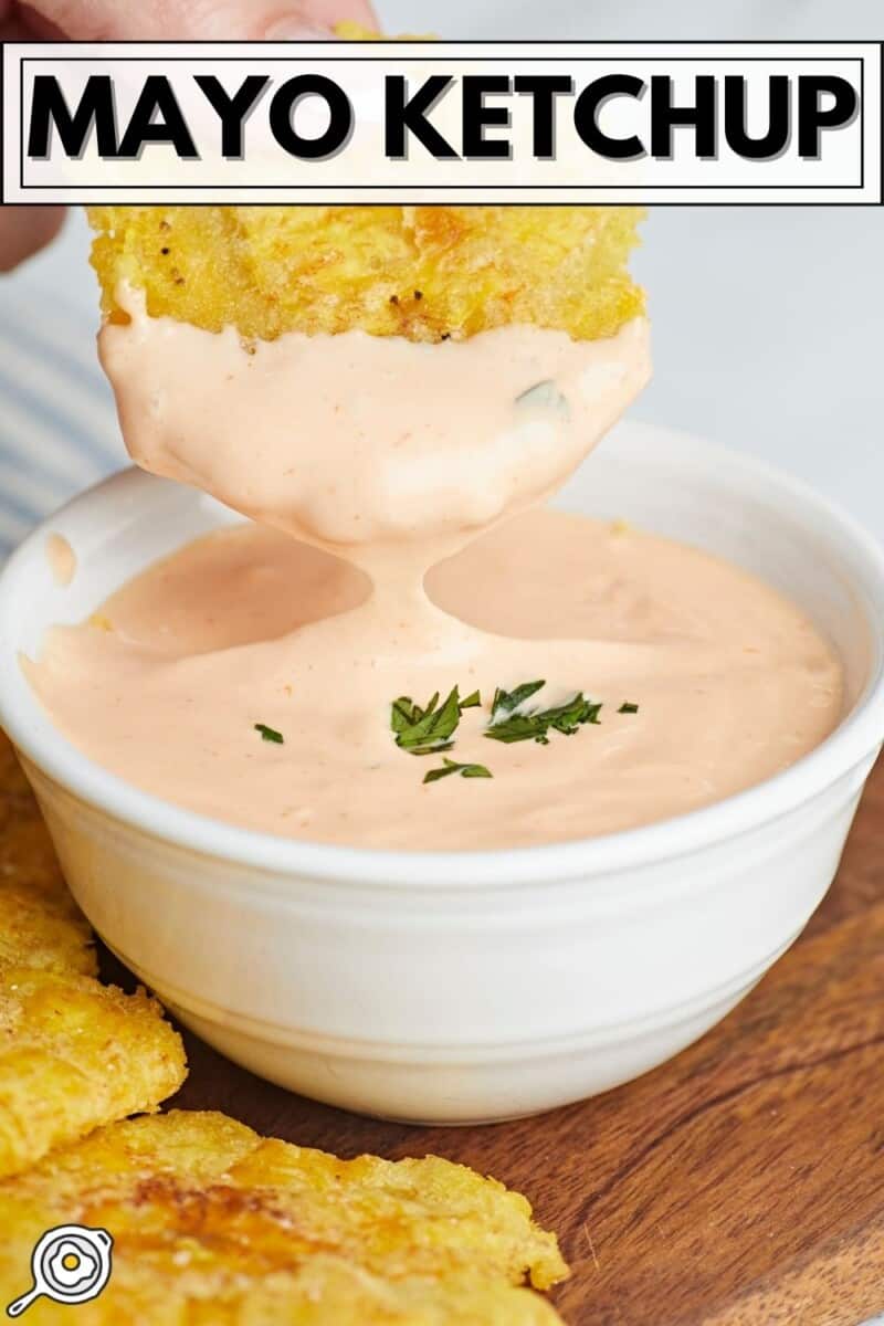 Side shot of toston being dipped in Mayo Ketchup in a small white bowl.