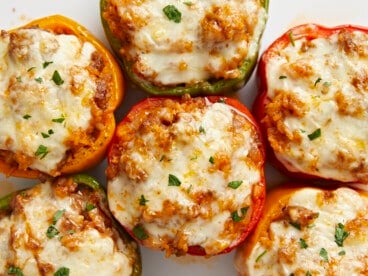 Overhead close up view of stuffed bell peppers on a serving plate.