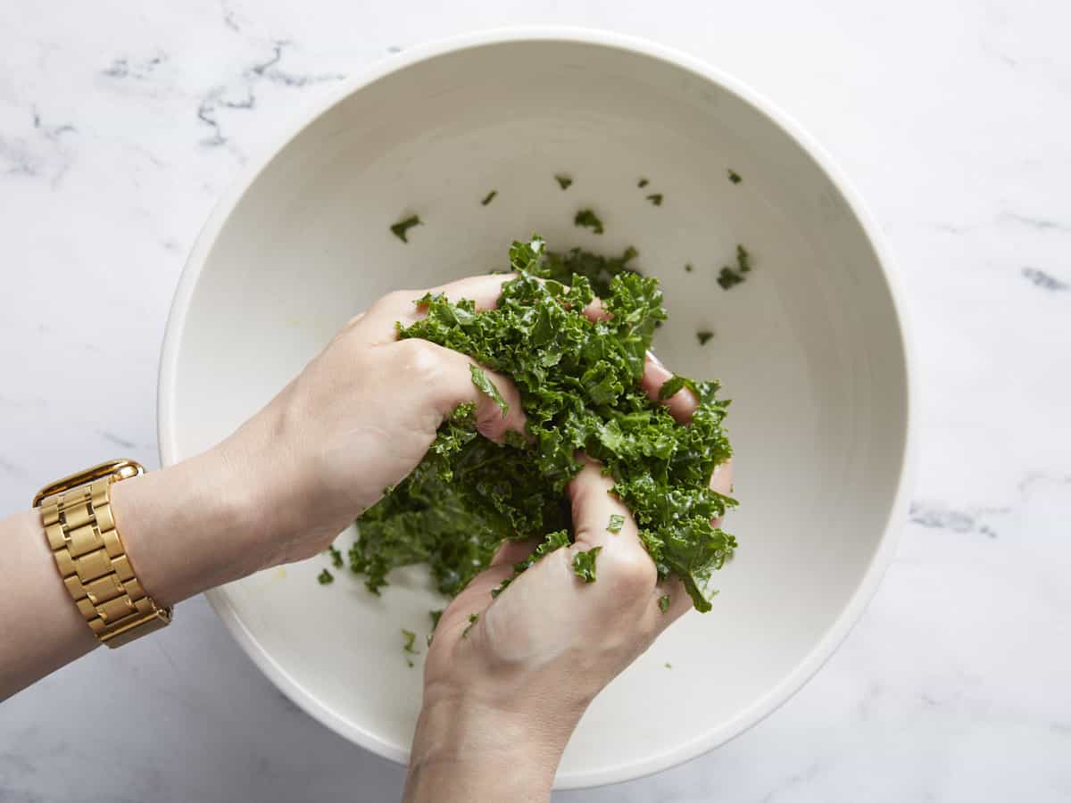 Kale being massaged by hand.