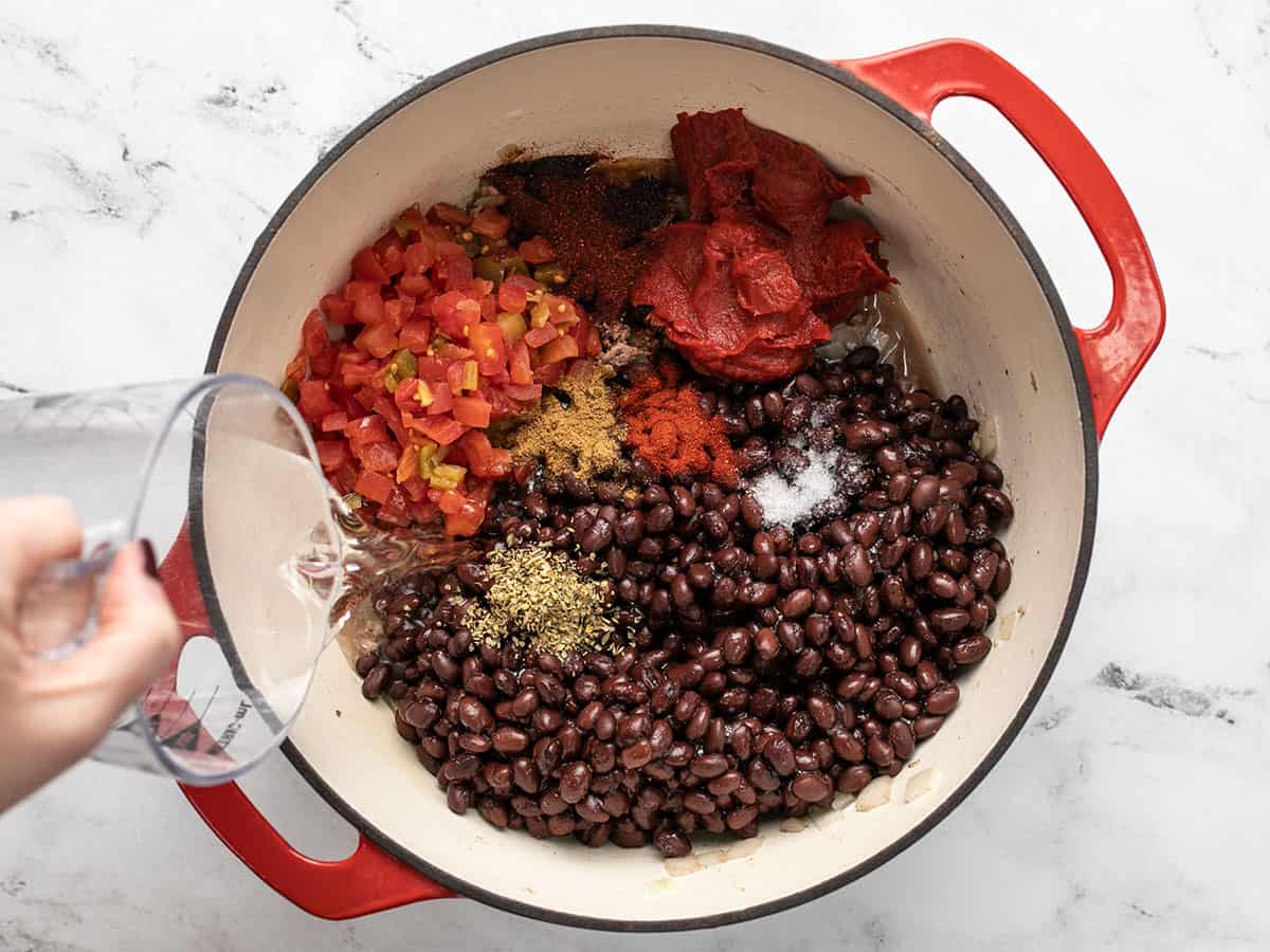 Tomatoes, spices, and water added to the soup pot.