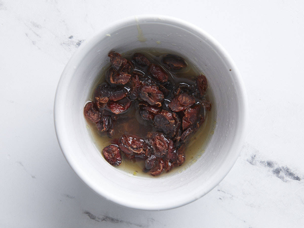 Cranberries marinating in a bowl.