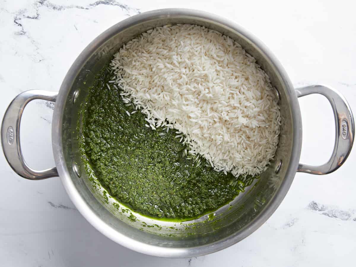 White rice added to green vegetable mixture in the pot