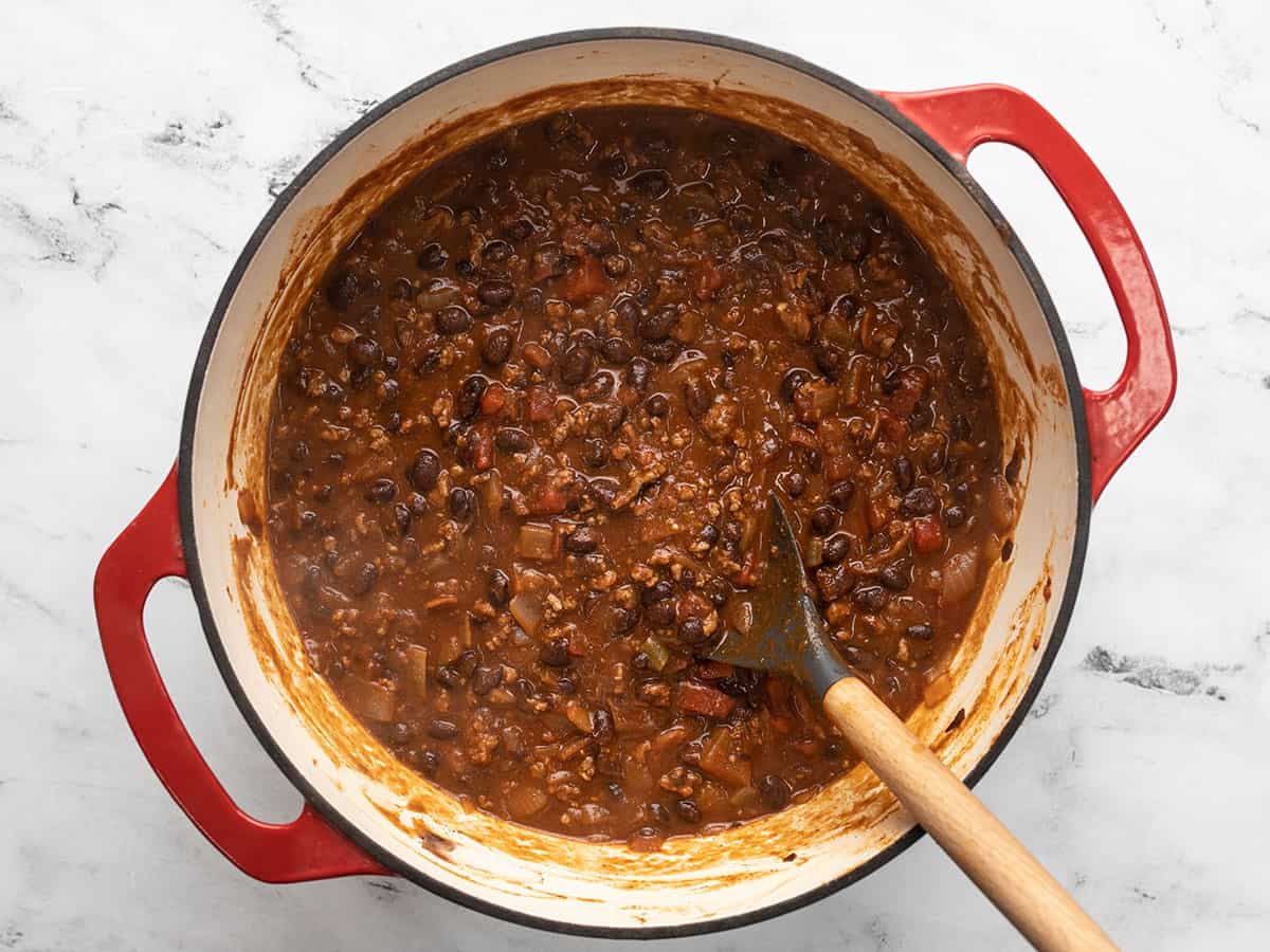 Simmered chili in the pot being stirred. 