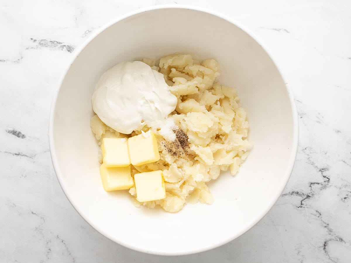 Potato flesh, butter, sour cream, milk, salt and pepper in a large bowl