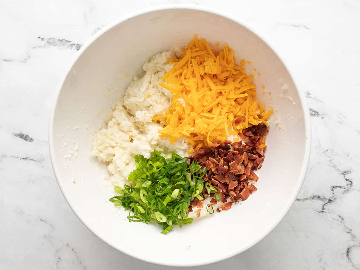 Chopped bacon, shredded cheddar cheese, and sliced green onion added to mashed potatoes.