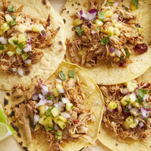 Close up overhead view of chipotle chicken tacos with limes on the side.