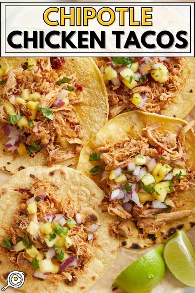 Close up overhead view of chipotle chicken tacos on a platter with limes.