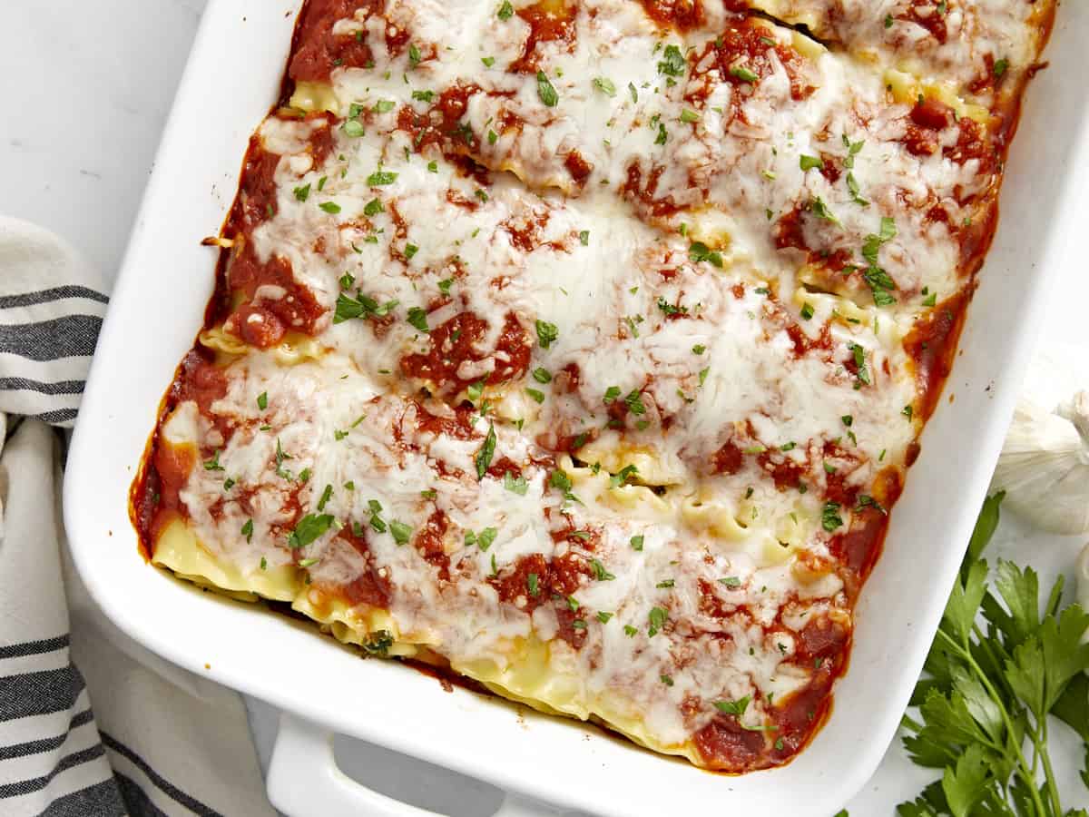 Finished lasagna roll ups in the baking dish, garnished with parsley.