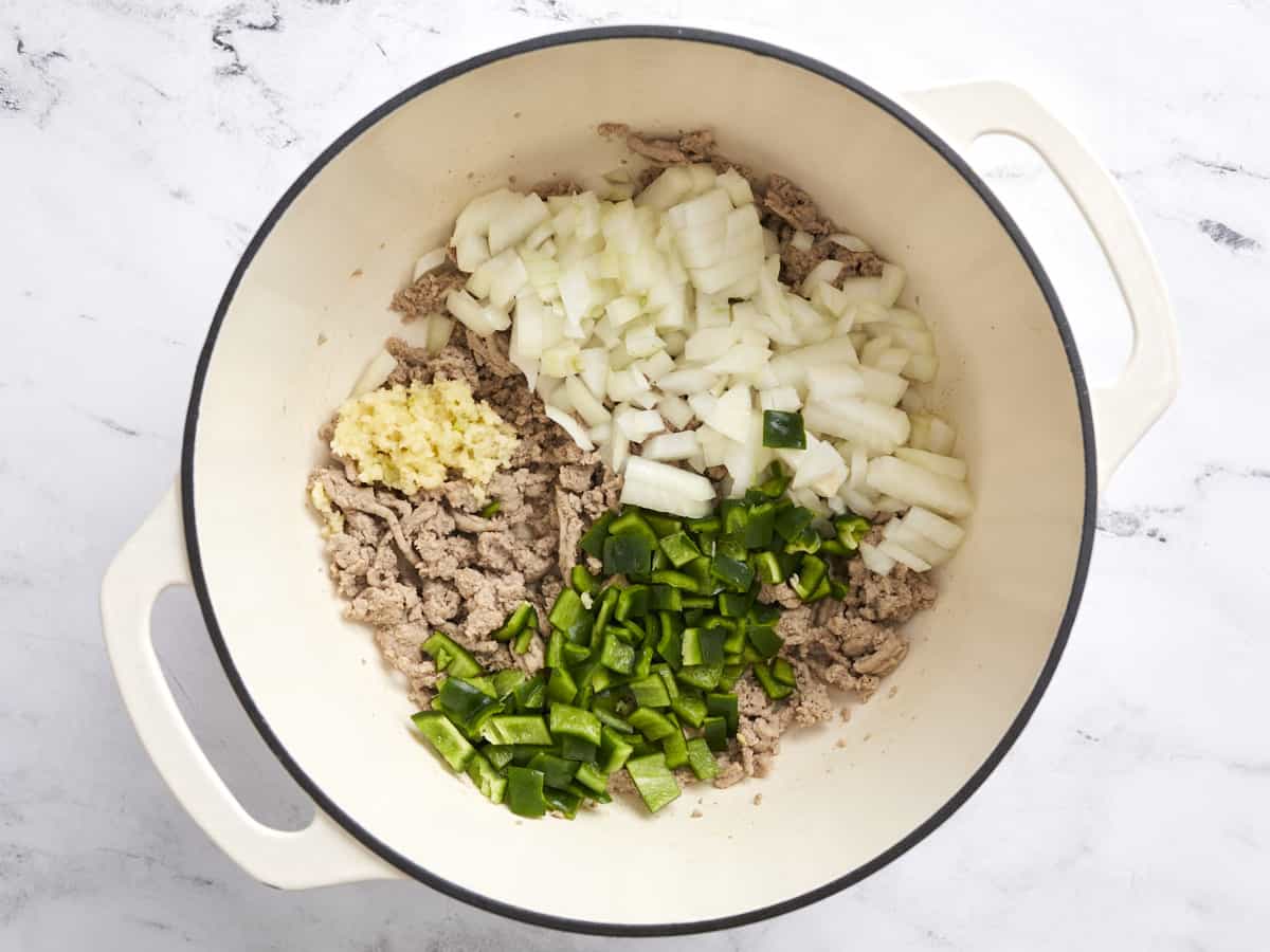 Onion, poblano pepper, and garlic added to the pot.