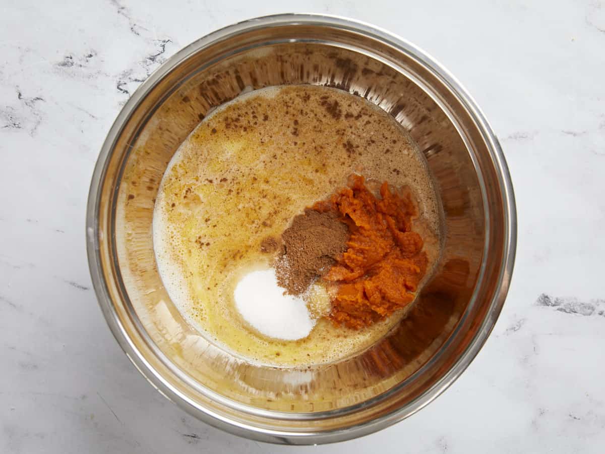 Pumpkin pie filling ingredients in a stainless steel bowl.