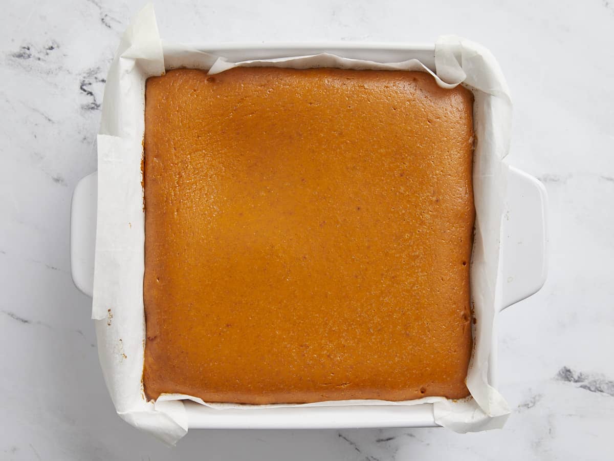 Overhead view of baked pumpkin pie bars in white baking dish.