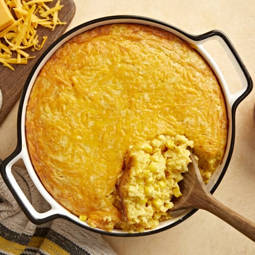 Overhead view of corn pudding being scooped out of the casserole dish.