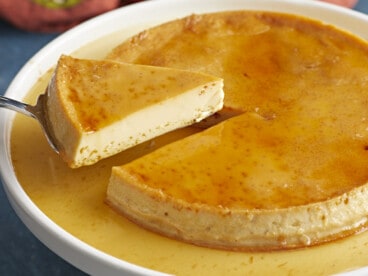 Side view of a piece of flan being lifted from the plate.