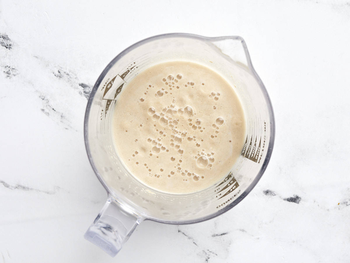 Frothy yeast water in a liquid measuring cup. 