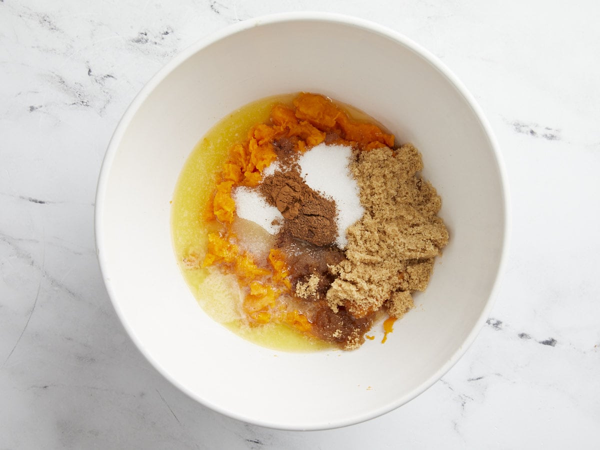 Mashed sweet potato with butter, sugars, and spices in a large bowl.