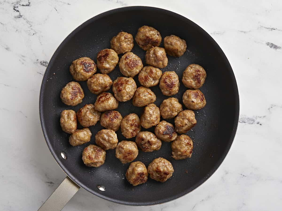 Browned meatballs in a skillet.