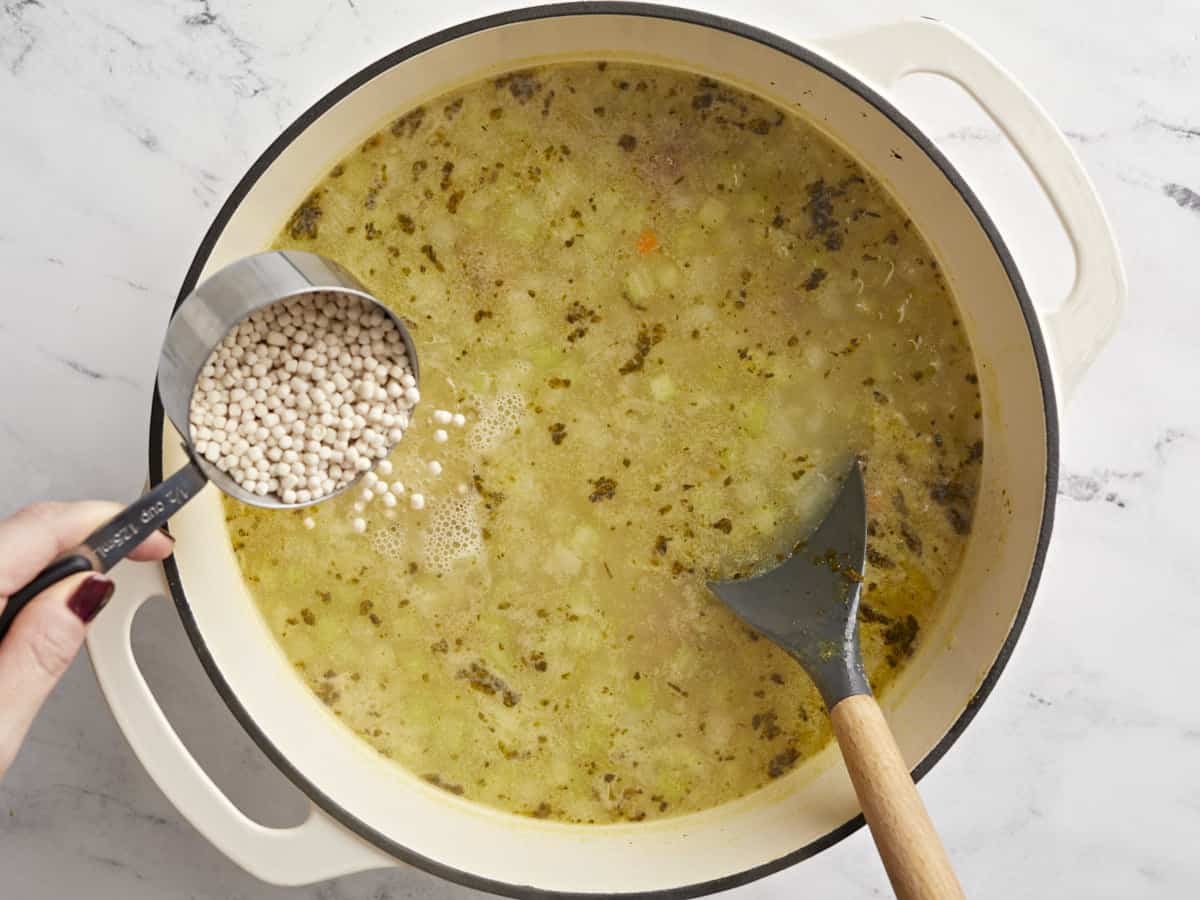 Pasta being added to the soup. 