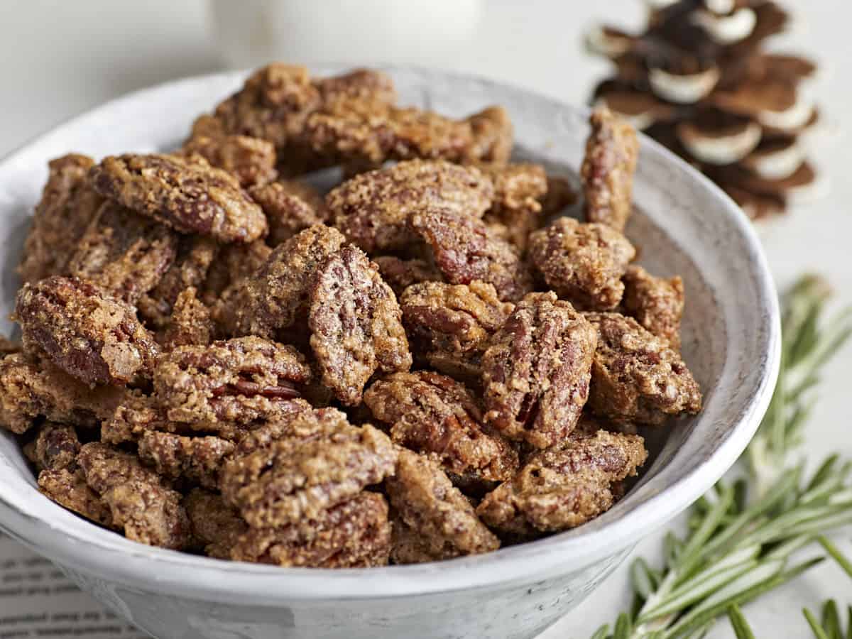 Side view of a bowl full of candied pecans. 