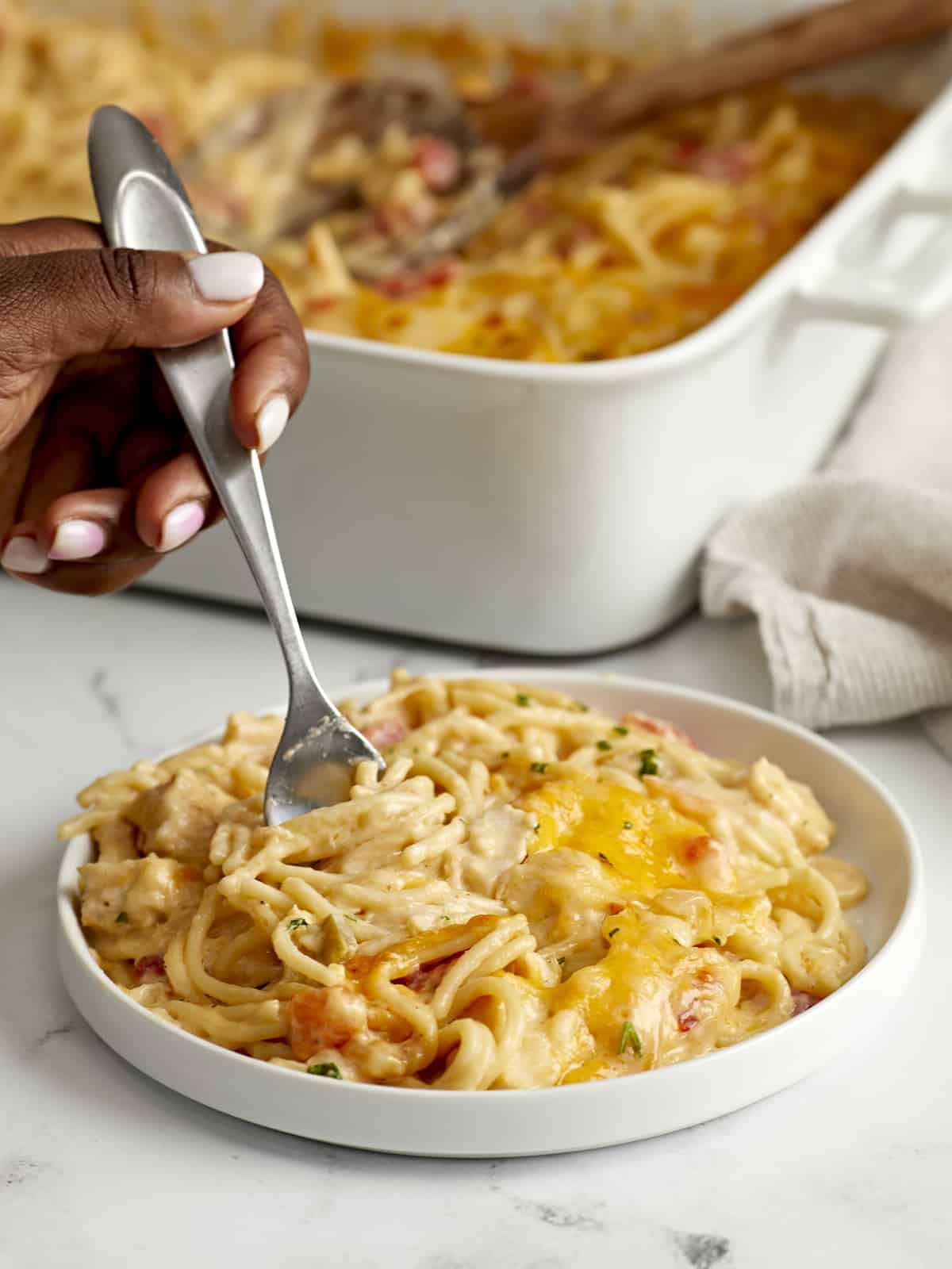 Side view of Chicken Spaghetti plated with a forklifting some out.