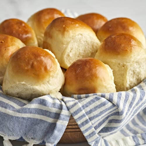 Side view of dinner rolls in a basket.