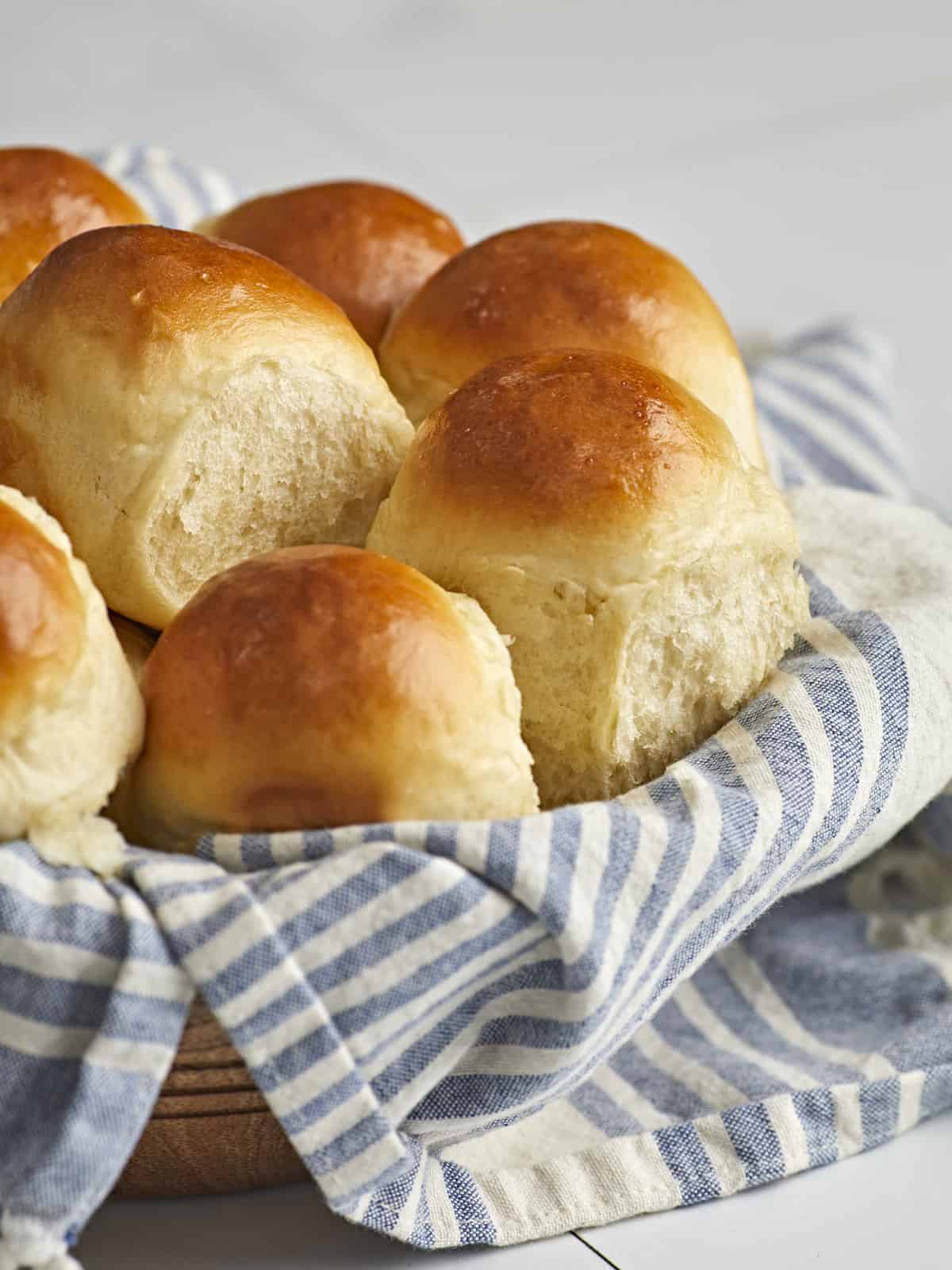 Side view of a basket full of homemade dinner rolls.