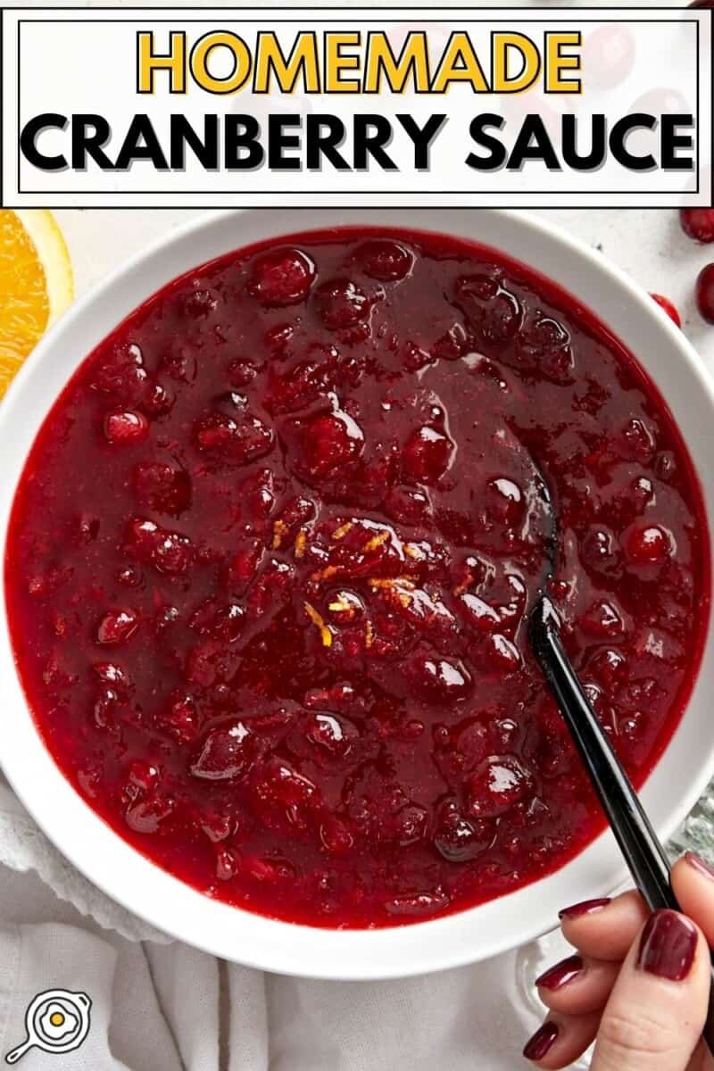 Overhead view of a bowl of cranberry sauce with a spoon.