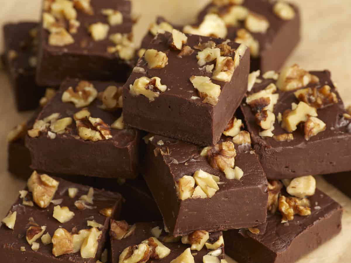 Side view of chocolate fudge squares stacked into a pile.