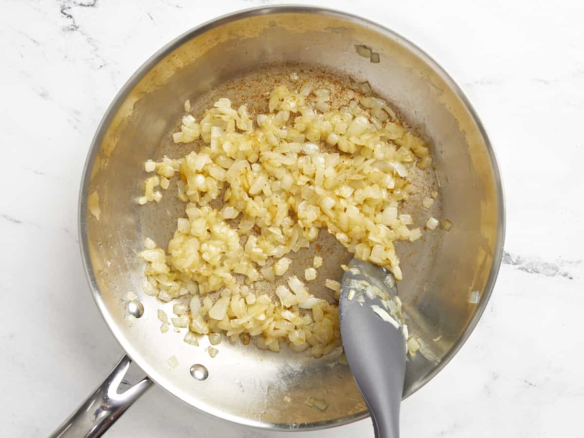 Half-cooked onions in the skillet. 