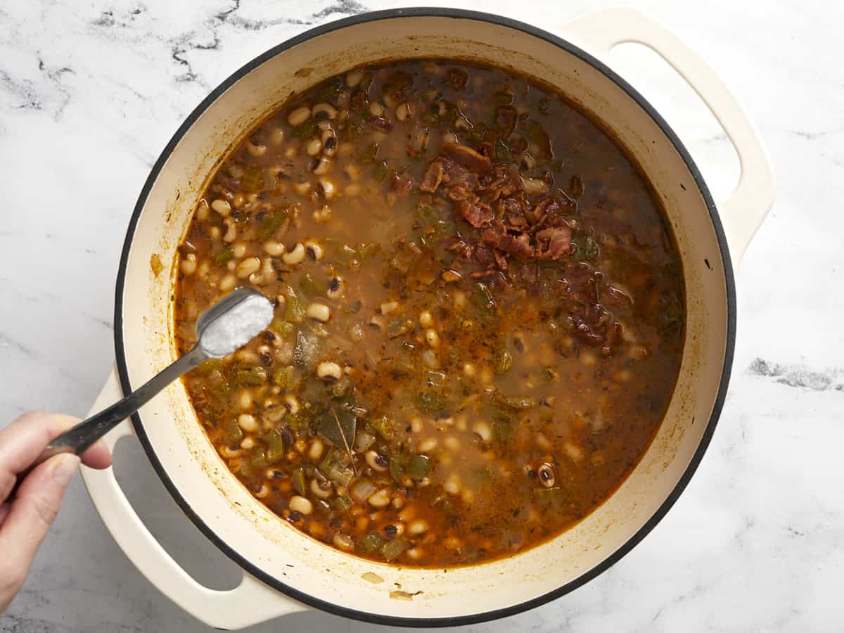 Salt being added to the pot of beans. 