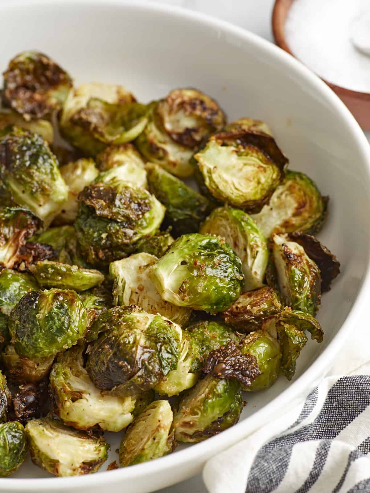 Side view of Air Fryer Brussels sprouts in a white serving dish.