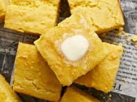 Close up overhead view of squares of cornbread with butter melting top.