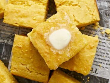 Close up overhead view of squares of cornbread with butter melting top.