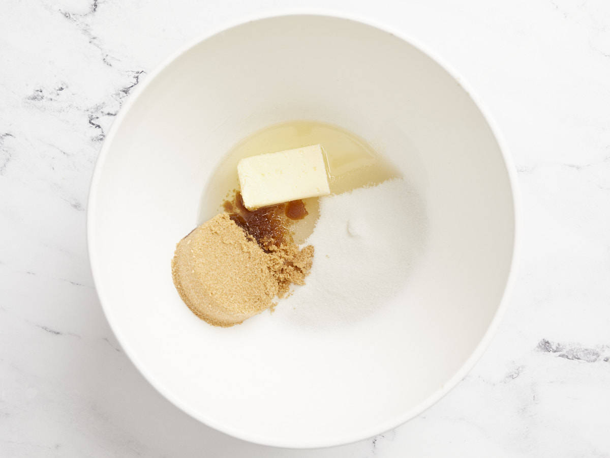 Butter, oil, and sugar added to a mixing bowl. 