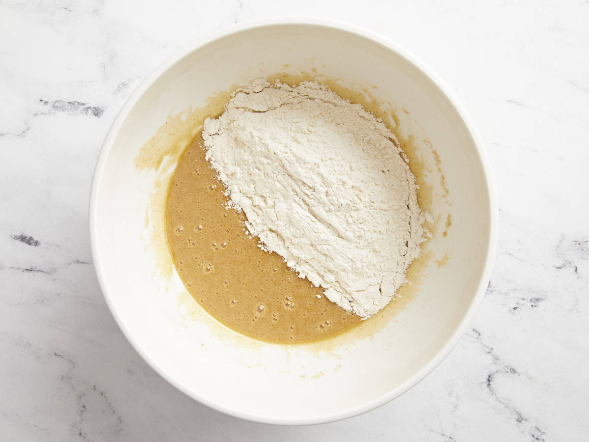 Dry ingredients added to wet ingredients in a bowl.