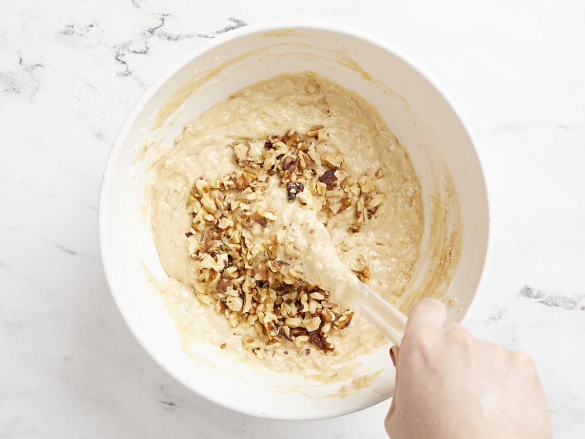 Chopped walnuts being folded into the banana bread batter. 