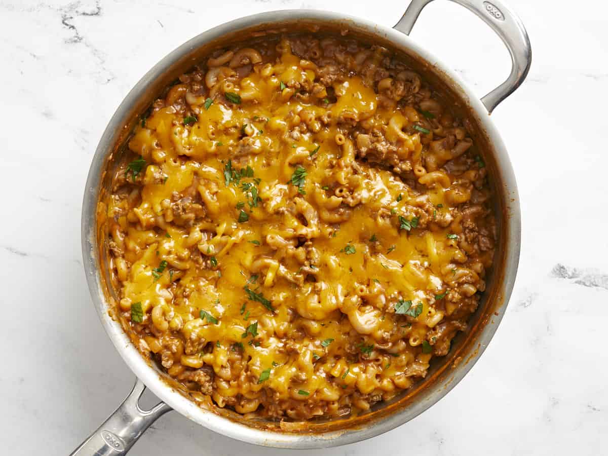 Melted cheese on top of the chili mac, garnished with chopped parsley. 