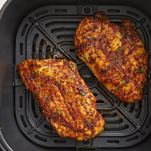 Cooked overhead view of Air Fryer Chicken Breasts in an air fryer basket.