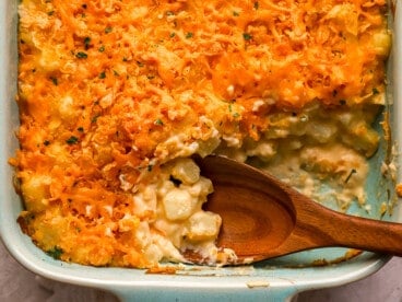 close up view of a wooden spoon in potato casserole.