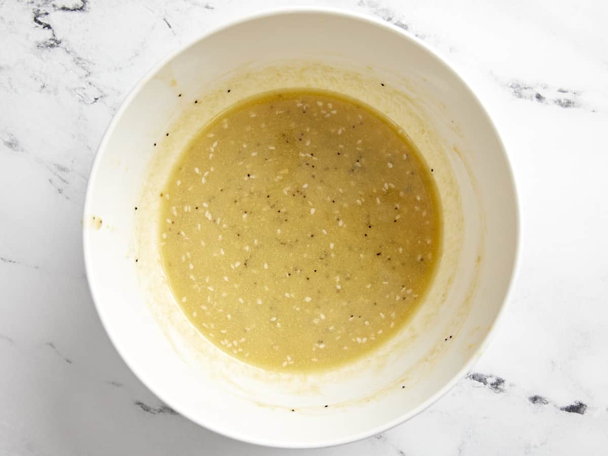 Overhead view of melted butter, Dijon mustard, Worcestershire sauce, and everything bagel seasoning mixed together in a small mixing bowl.