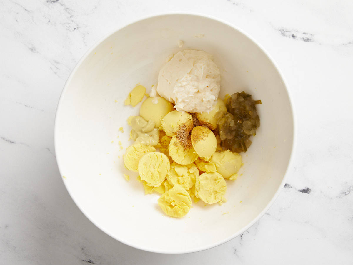 The filling ingredients for deviled eggs in a small mixing bowl.